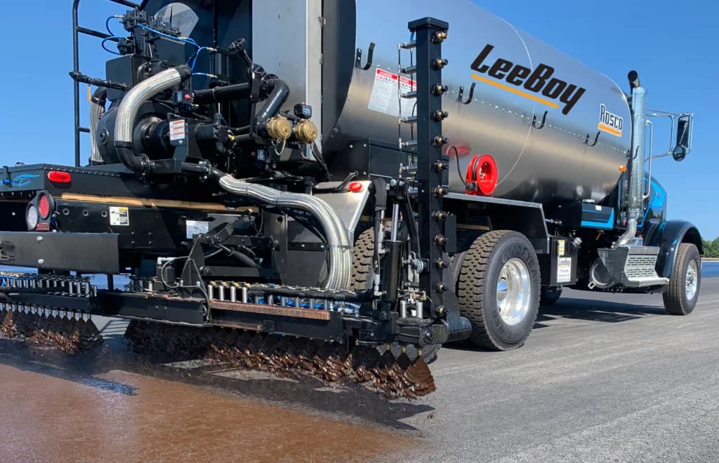 Rosco Maximizer 4B asphalt distributor spraying through its spray bar
